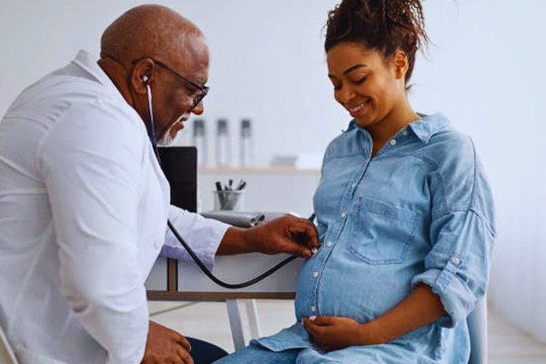 Pregnancy check-up in progress as a smiling expectant mother consults with her gynecologist. This prenatal visit highlights key moments in understanding the difference between NIPT and CVS during early pregnancy screening.