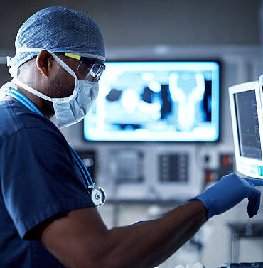 Shot of a surgeon looking at a monitor in an operating room