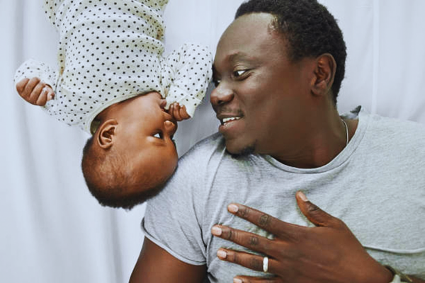 Cropped shot of a man spending quality time with his baby girl at home, highlighting family bonding and the emotional impact of paternity fraud