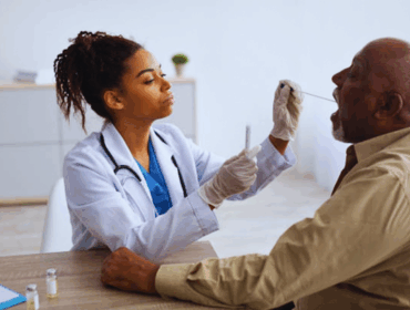 _When can you Get A Paternity Test Expert Insights on Timing, Legal, and Personal Reasons Black medical worker performing a COVID-19 PCR swab test on a mature male patient, illustrating diagnostic procedures and raising awareness about when you can get a paternity test during medical situations.