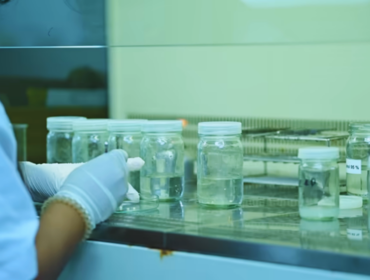Asian scientist working in a laboratory conducting experiments and reviewing results, illustrating careful sample analysis in a scientific research process.
